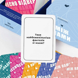 Настольная игра Між нами от Sovabooks для вечеринок и развлечений, изображение коробки с ярким дизайном и логотипом.