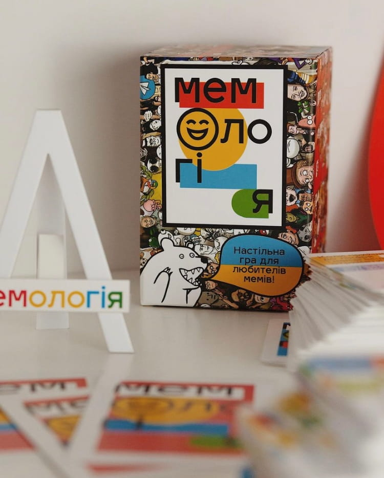 Настольная игра Мемологія от SOVABOOKS для веселых партий и интеллектуальных развлечений, изображение коробки и компонентов.