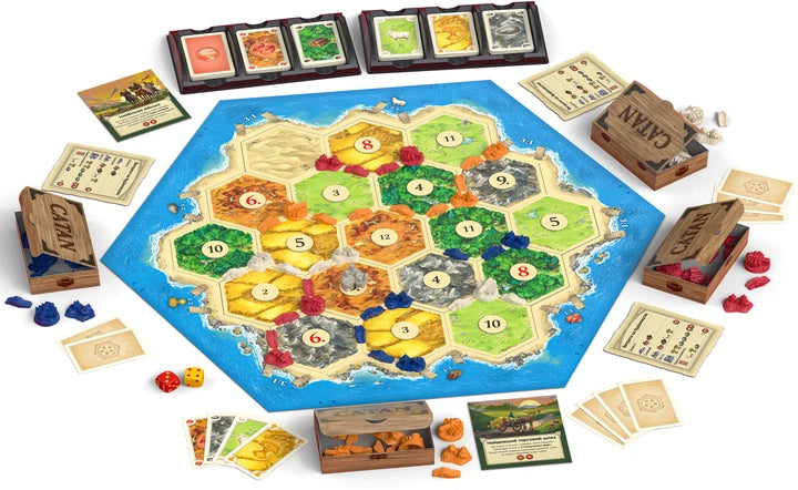 Настольная игра "CATAN" от Sovabooks, изображение коробки с игровым полем и компонентами для развлечений.